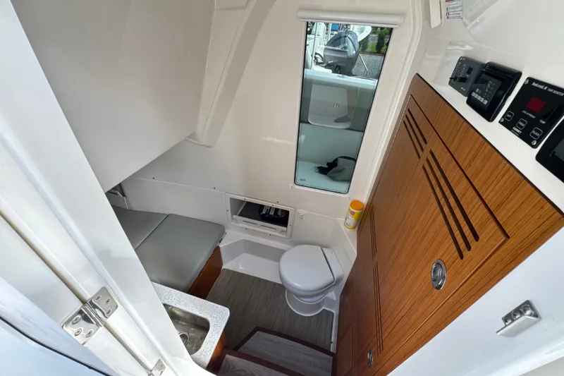 Slide: The Image of Interior of 2026 Solace 32CS boat featuring compact bathroom and wooden cabinetry. - 23