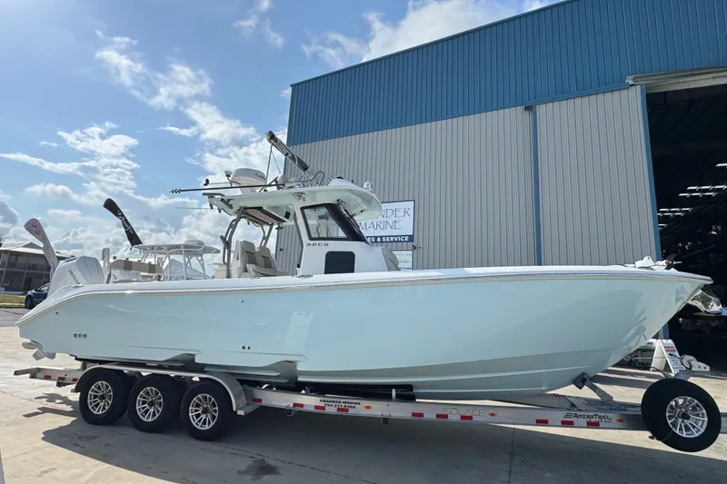 Slide: The Image of 2026 Solace 32CS boat on trailer outside a marine service building. - 2