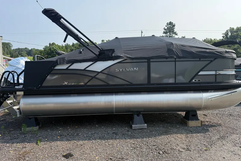 Slide: The Image of 2026 Sylvan X1 CLZ DH pontoon boat with black cover on gravel lot. - 26