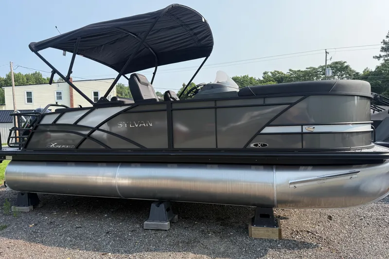 The Image of 2026 Sylvan X1 CLZ DH pontoon boat with canopy, parked on gravel. - 1