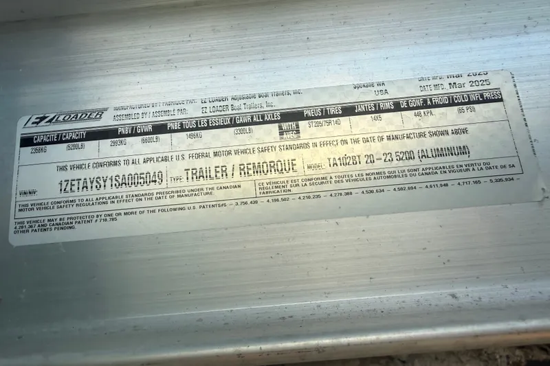 Slide: The Image of Label on EZ Loader trailer, model TA102BT 20-23 5200, manufactured March 2025. - 28