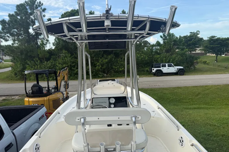 Slide: The Image of 2025 Bulls Bay 2200 XS boat with T-top and Garmin electronics, parked outdoors. - 22