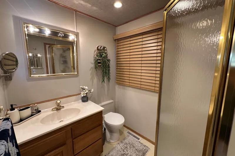 Slide: The Image of Bathroom in 1999 Sumerset 16x75 houseboat with vanity, mirror, and shower. - 11