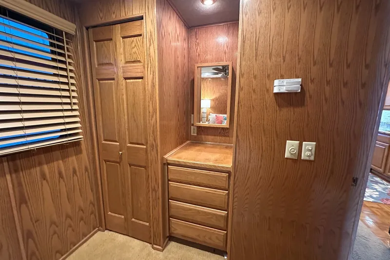 Slide: The Image of Wood-paneled interior of a 1999 Sumerset 16x75 houseboat with closet and dresser. - 8