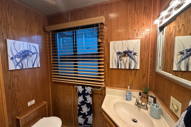 Slide: The Image of Wood-paneled bathroom in 1999 Sumerset 16x75 houseboat with turtle-themed decor. - 9