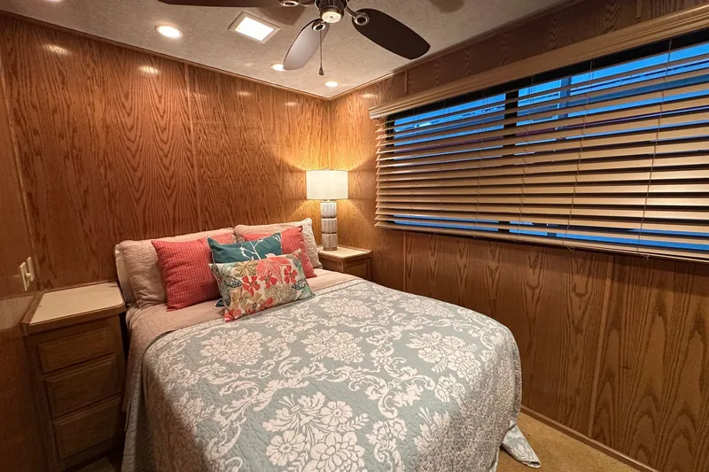 Slide: The Image of Cozy bedroom in 1999 Sumerset 16x75 houseboat with wood paneling and decorative bedding. - 7