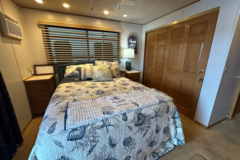 Slide: The Image of Cozy bedroom in a 1999 Sumerset 16x75 houseboat with floral bedding and wooden accents. - 10