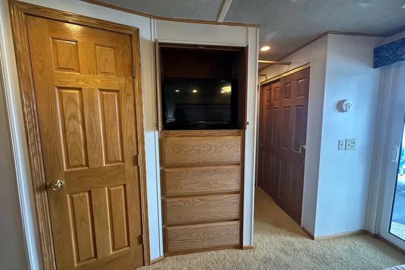 Slide: The Image of Interior of 1999 Sumerset 16x75 houseboat with wooden doors and built-in TV cabinet. - 12