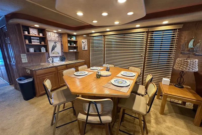Slide: The Image of Dining area in a 1999 Sumerset 16x75 houseboat with wooden table and chairs. - 6
