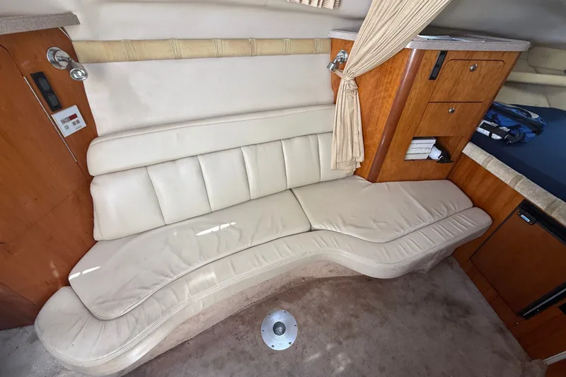 Slide: The Image of Interior of 2003 Regal Commodore 2860 boat with cream leather seating and wooden cabinetry. - 8