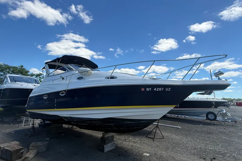 The Image of 2003 Regal Commodore 2860 boat on dry dock under a clear blue sky. - 0