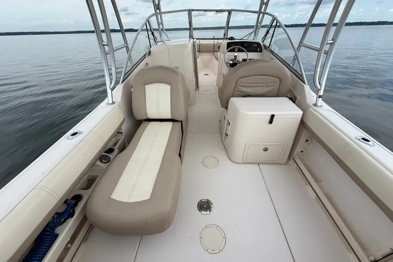 Slide: The Image of 2013 Grady-White Freedom 275 boat interior with beige seating on calm water. - 15