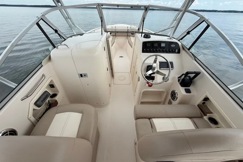Slide: The Image of 2013 Grady-White Freedom 275 boat interior with steering wheel and dashboard controls. - 19