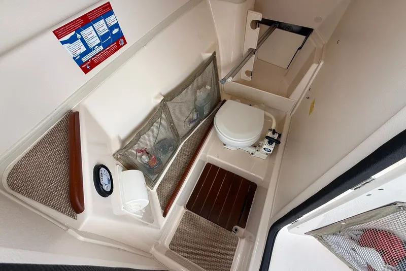 Slide: The Image of 2013 Grady-White Freedom 275 boat interior with compact marine toilet and storage. - 22