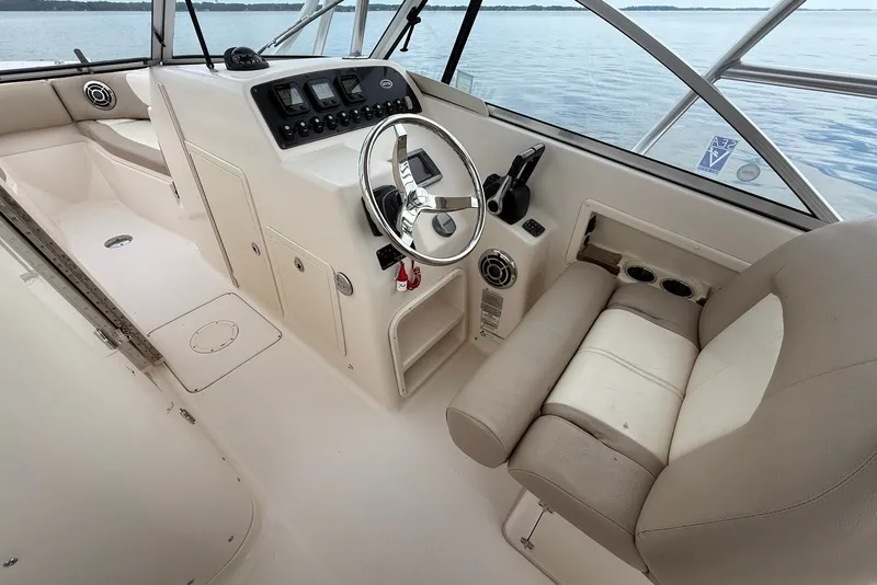 Slide: The Image of 2013 Grady-White Freedom 275 boat cockpit with steering wheel and control panel. - 24