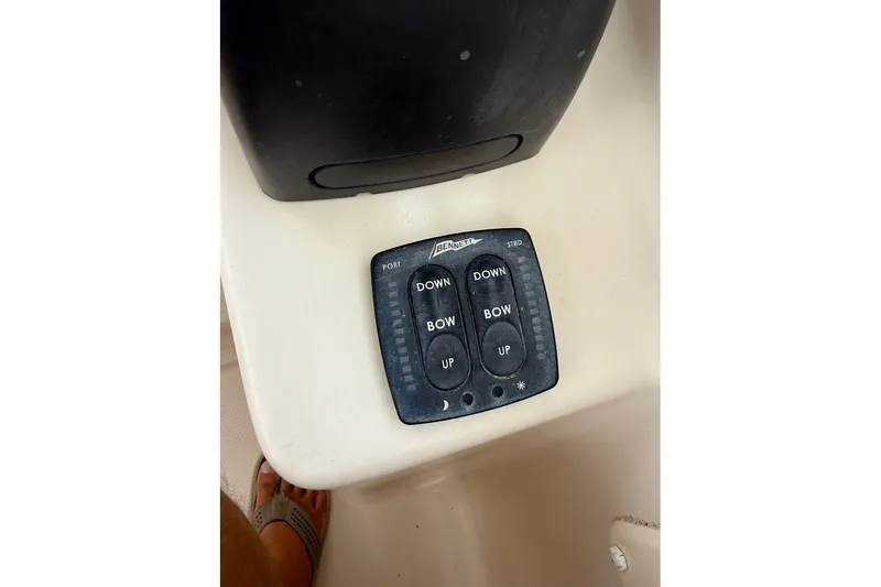 Slide: The Image of Control panel on a 2013 Grady-White Freedom 275 boat, featuring trim tab buttons. - 32