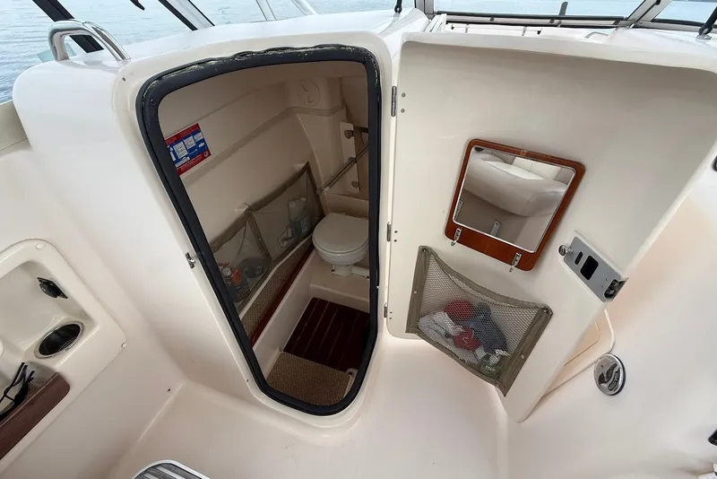 Slide: The Image of 2013 Grady-White Freedom 275 boat interior with compact bathroom and storage. - 21