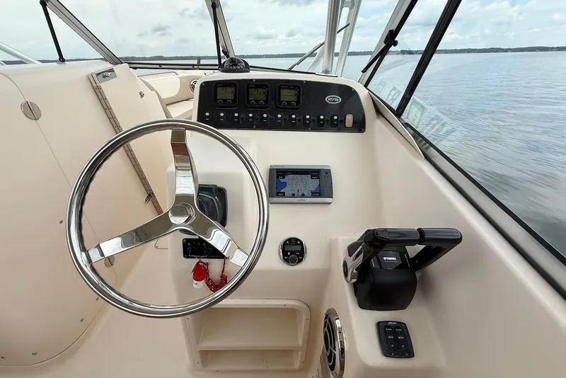 Slide: The Image of 2013 Grady-White Freedom 275 boat dashboard with steering wheel and navigation controls. - 25