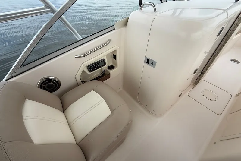 Slide: The Image of 2013 Grady-White Freedom 275 boat interior with beige seating and audio system. - 20