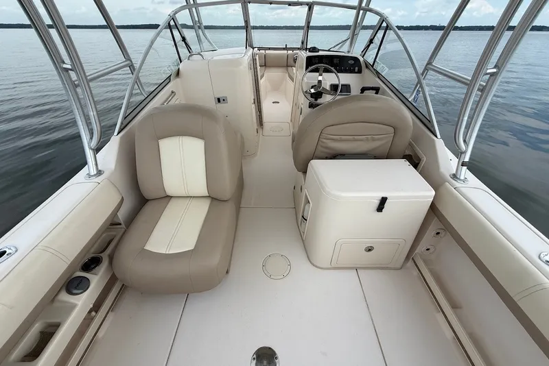Slide: The Image of 2013 Grady-White Freedom 275 boat interior with beige seating and steering console. - 14