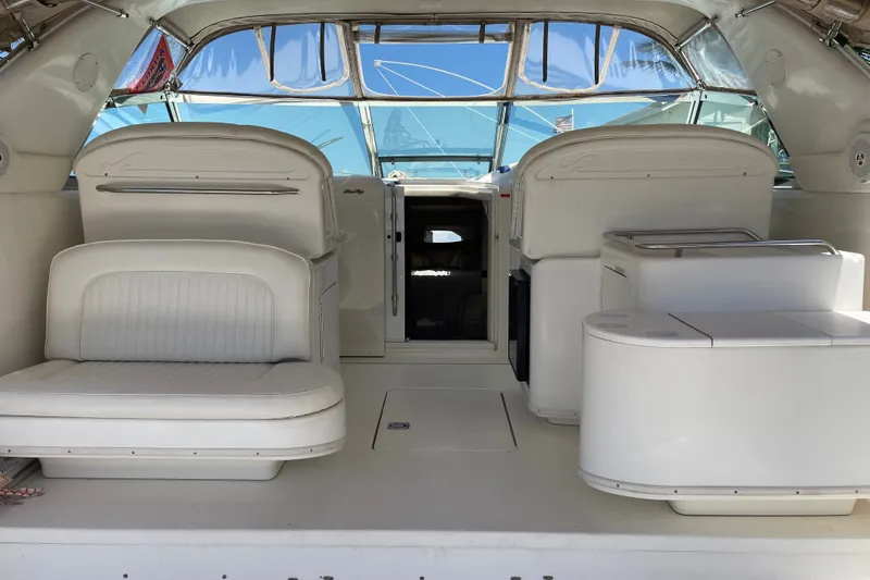 Slide: The Image of 1997 Sea Ray 370 Express Cruiser interior with white seating and open cabin entrance. - 9