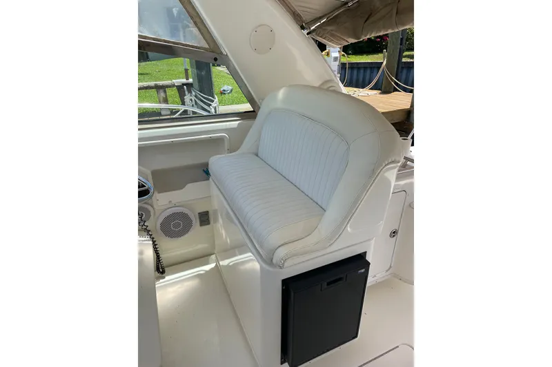 Slide: The Image of 1997 Sea Ray 370 Express Cruiser interior with white cushioned seating and storage compartment. - 8