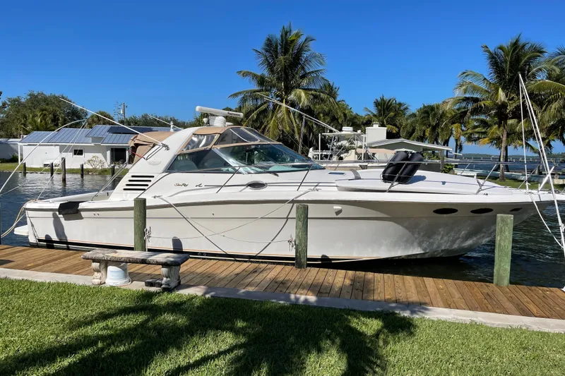 The Image of 1997 Sea Ray 370 Express Cruiser docked by palm trees, sunny day. - 0