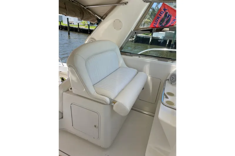 Slide: The Image of 1997 Sea Ray 370 Express Cruiser interior with white seating and Florida flag. - 7