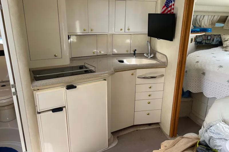 Slide: The Image of Interior of 1997 Sea Ray 370 Express Cruiser with kitchenette and cozy sleeping area. - 12