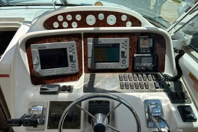 Slide: The Image of Control panel of a 1997 Sea Ray 370 Express Cruiser with navigation equipment and gauges. - 4