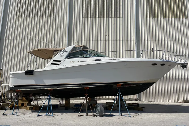Slide: The Image of 1997 Sea Ray 370 Express Cruiser on stands, side view, in front of a large building. - 1
