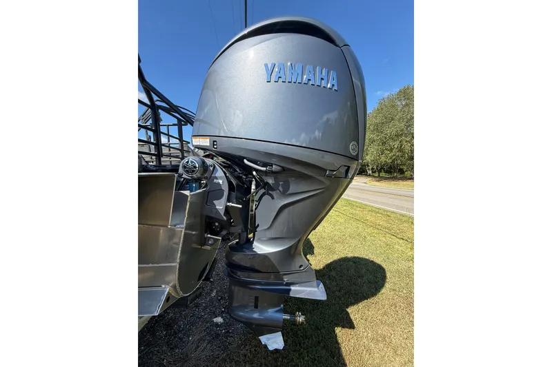 Slide: The Image of Yamaha outboard motor on 2026 Sylvan X-3 CLZ DH boat, parked on grass. - 25