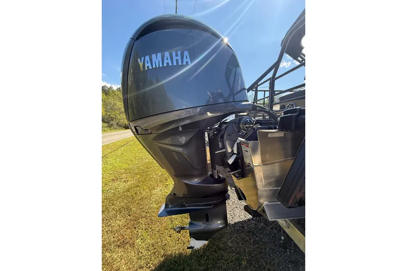 Slide: The Image of Yamaha outboard motor on a 2026 Sylvan X-3 CLZ DH boat, parked on grass. - 24