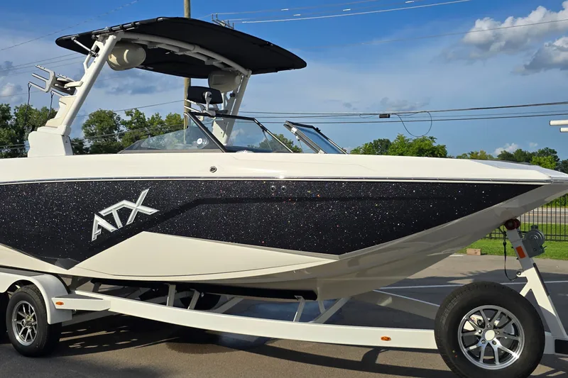 The Image of 2023 ATX Surf Boats 24 Type-S on trailer, sleek design with black and white finish. - 1