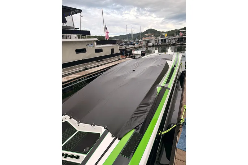 Slide: The Image of 2022 Daves Custom Boats M-44 covered at marina, featuring sleek green accents. - 9