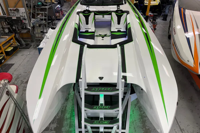 Slide: The Image of 2022 Daves Custom Boats DCB M-44 with sleek green and white design in workshop. - 14