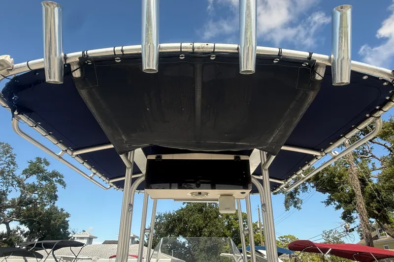 Slide: The Image of T-top of 2002 Grady-White Fisherman 222 boat with rod holders, under blue sky. - 27