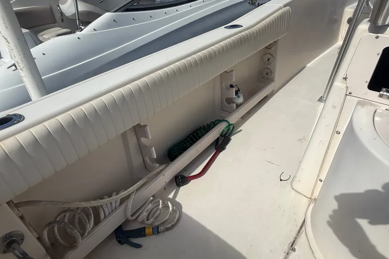 Slide: The Image of 2002 Grady-White Fisherman 222 boat interior with storage compartments and coiled hoses. - 22