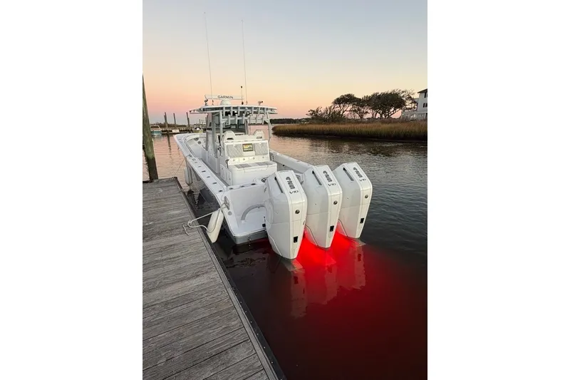 Slide: The Image of 2026 Onslow Bay 37 Tournament Edition boat docked at sunset with illuminated engines. - 117