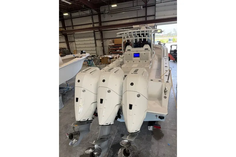Slide: The Image of 2026 Onslow Bay 37 Tournament Edition boat with triple outboard engines in a warehouse. - 96