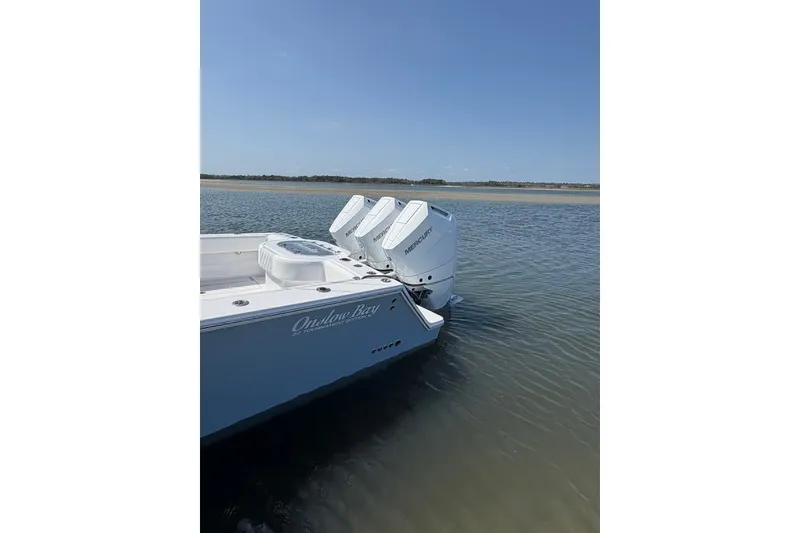 Slide: The Image of Onslow Bay 37 Tournament Edition 2026 boat with triple Mercury engines on calm water. - 33