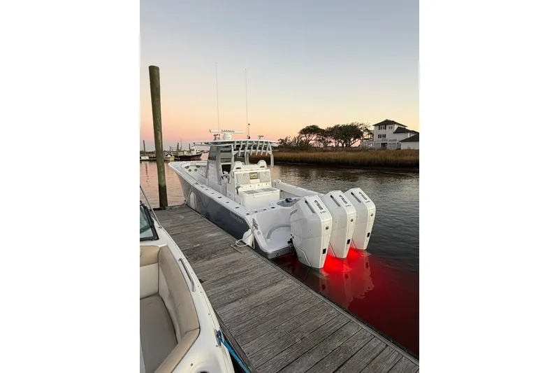 Slide: The Image of 2026 Onslow Bay 37 Tournament Edition boat docked at sunset with triple engines. - 118