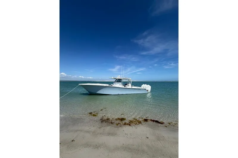 Slide: The Image of 2026 Onslow Bay 37 Tournament Edition boat anchored in clear blue water near sandy shore. - 37