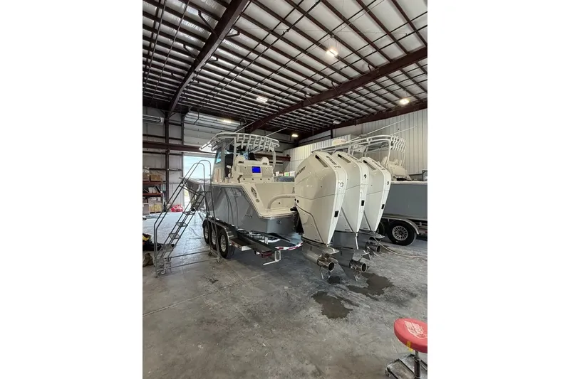 Slide: The Image of 2026 Onslow Bay 37 Tournament Edition boat in a warehouse, featuring triple outboard engines. - 94