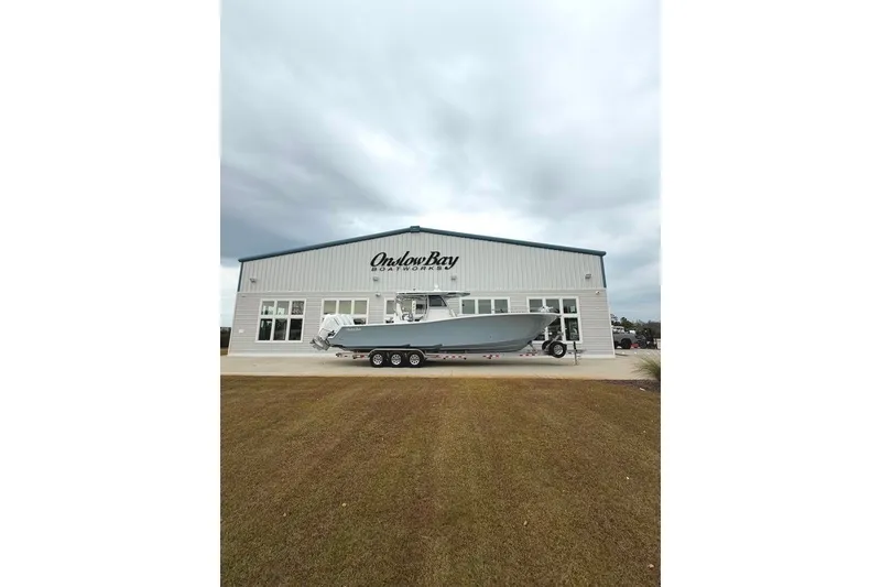 Slide: The Image of Onslow Bay 37 Tournament Edition 2026 boat outside showroom on cloudy day. - 111