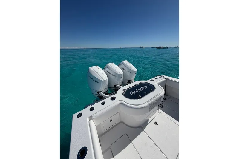 Slide: The Image of 2026 Onslow Bay 37 Tournament Edition boat with triple Mercury engines on clear blue water. - 126