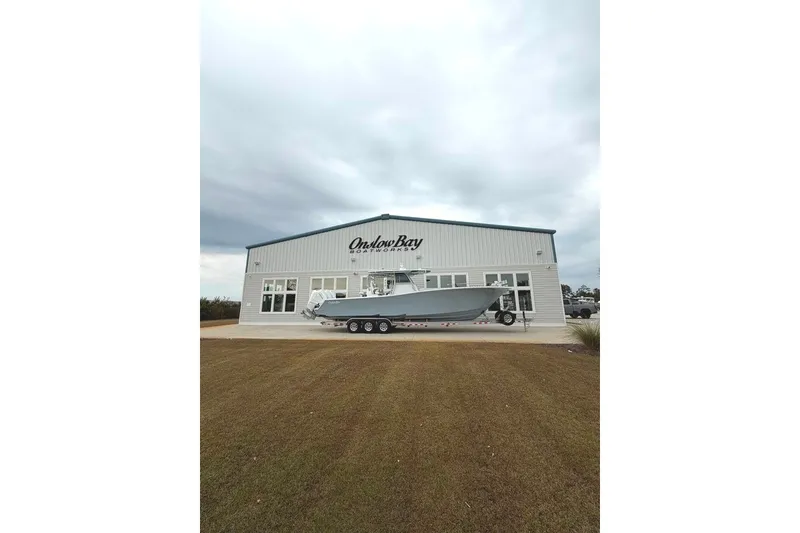 Slide: The Image of Onslow Bay 37 Tournament Edition 2026 boat outside showroom on cloudy day. - 107