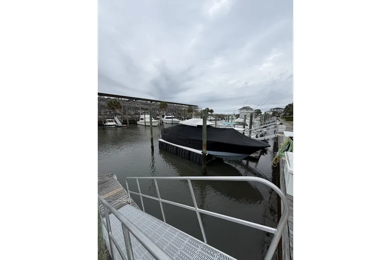Slide: The Image of Covered Onslow Bay 37 Tournament Edition boat docked in a marina, 2026 model. - 130