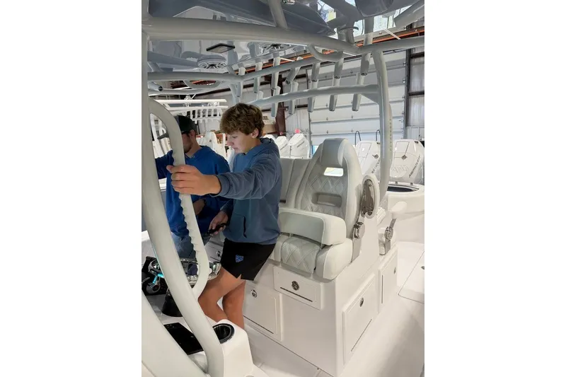 Slide: The Image of Two people on a 2026 Onslow Bay 37 Tournament Edition boat in a garage. - 77