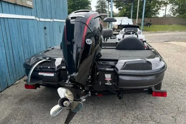 Slide: The Image of 2026 Nitro Z17 boat with powerful outboard motor, parked near blue building. - 5